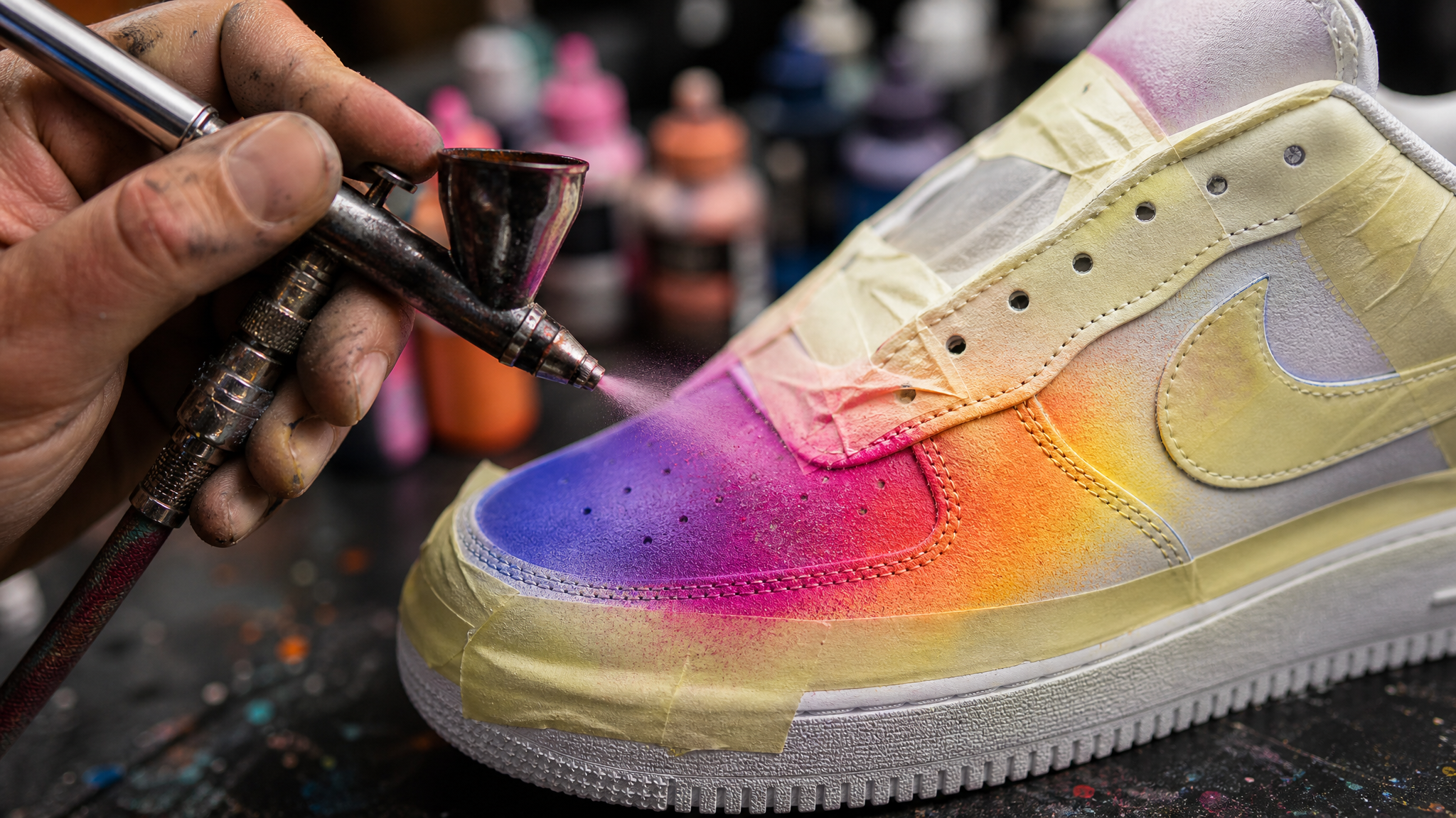 Sneaker die met een airbrushpistool wordt beschilderd tijdens het customizen